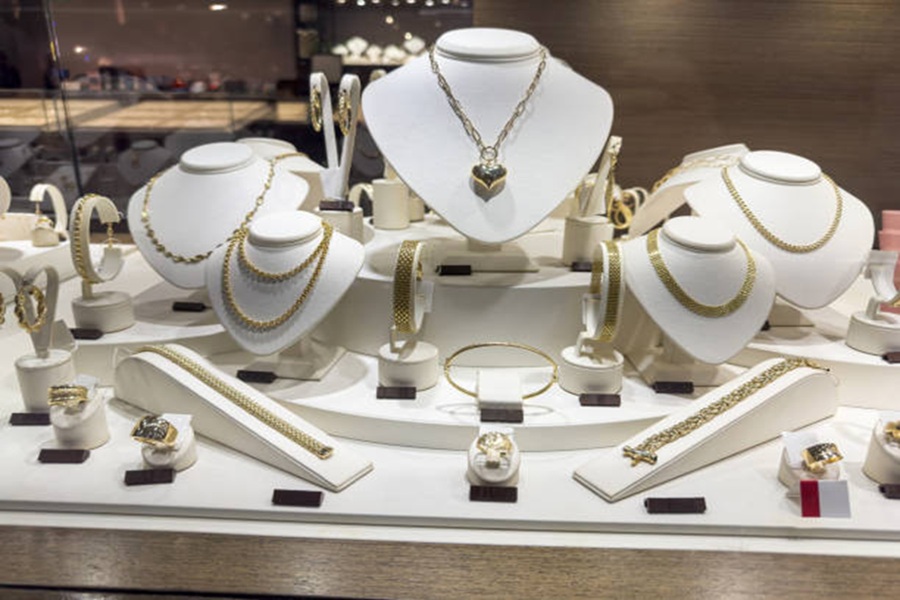 Showcase of a golden jewellery on necklace stand. Jewelry store show, nobody